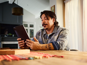 Man sitting at table talking to a doctor on his ipad