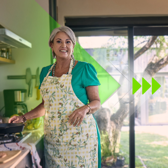 Woman in apron in her kitchen cooking.